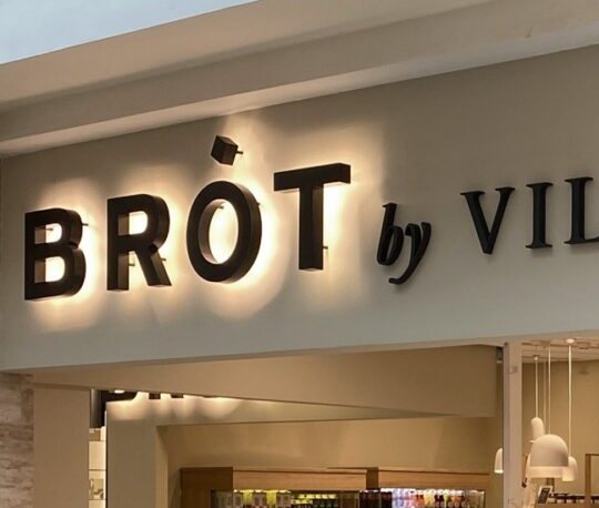A hátulról világító BRÓT betűk a portálon közelről
