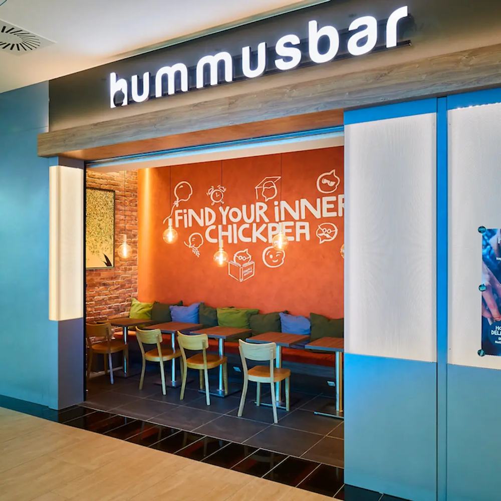 A Hummusbar háttérvilágított logója a bejárat felett